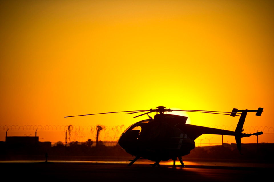 Unmanned Little Bird H-6U silhouetted against sunset